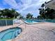 Community pool featuring lounge chairs, a jacuzzi, mature trees, and manicured landscaping at 6505 Stone River Rd # 309, Bradenton, FL 34203