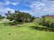 Backyard view of golf course, trees, and lush green grass at 6505 Stone River Rd # 309, Bradenton, FL 34203