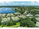 Aerial view of the community with a picturesque lake, lush landscaping, and community pool at 6536 Moorings Point Cir # 101, Lakewood Ranch, FL 34202