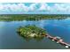 Stunning aerial view showcases the serene lake, charming island, pier, and lush landscapes at 6536 Moorings Point Cir # 101, Lakewood Ranch, FL 34202