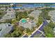 Expansive aerial view of the community showcasing a pool, clubhouse, surrounding lush greenery, and tranquil lake at 6536 Moorings Point Cir # 101, Lakewood Ranch, FL 34202