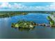 Breathtaking aerial view of community lake, featuring lush greenery, a charming island, and a scenic pier at 6536 Moorings Point Cir # 101, Lakewood Ranch, FL 34202
