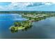 Aerial shot showcases the community lake with picturesque views of well-maintained homes and lush greenery at 6536 Moorings Point Cir # 101, Lakewood Ranch, FL 34202