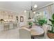 A dining space with an inviting round wood table set beneath a stylish lighting fixture next to the open kitchen at 6536 Moorings Point Cir # 101, Lakewood Ranch, FL 34202