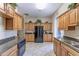 Well-equipped kitchen with wood cabinets, granite countertops, stainless steel appliances, and tile flooring at 6536 Moorings Point Cir # 101, Lakewood Ranch, FL 34202