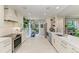 A modern white kitchen featuring stainless appliances, sleek cabinetry, and easy access to a patio dining area at 6536 Moorings Point Cir # 101, Lakewood Ranch, FL 34202