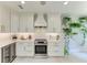 A well-lit kitchen featuring white cabinets, sleek appliances, and a wine cooler, perfect for modern cooking at 6536 Moorings Point Cir # 101, Lakewood Ranch, FL 34202