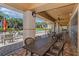 Inviting covered patio with brick flooring featuring metal tables and chairs overlooking a lush tropical landscape and community pool at 6536 Moorings Point Cir # 101, Lakewood Ranch, FL 34202