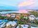 Stunning aerial view of waterfront homes, lush greenery, and a serene bay under a colorful sky at 701 Marbury Lane, Longboat Key, FL 34228