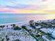 Gorgeous aerial view of beach front property with gulf waters and a pastel sky at 701 Marbury Lane, Longboat Key, FL 34228
