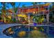 Tropical backyard with a sparkling pool, lush greenery, and a spacious two-story home at 701 Marbury Lane, Longboat Key, FL 34228