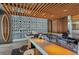 Modern bar area with wood ceiling, decorative block wall, surfboards, and stainless steel counter at 701 Marbury Lane, Longboat Key, FL 34228
