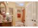 Bathroom area showcasing stone floors, a vintage cabinet vanity, a skylight and a stall shower with orange accents at 701 Marbury Lane, Longboat Key, FL 34228