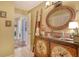Unique bathroom vanity with a round mirror, ladder rack, and painted cabinet, blending function and style in a cozy space at 701 Marbury Lane, Longboat Key, FL 34228