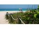 Scenic beach view with soft sand, clear turquoise water, and lush vegetation along the shoreline at 701 Marbury Lane, Longboat Key, FL 34228