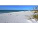 Picturesque beach with white sand, calm turquoise water, and sparse greenery along the shoreline at 701 Marbury Lane, Longboat Key, FL 34228