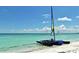 Serene beach scene featuring a catamaran on the white sand with clear turquoise water and a blue sky at 701 Marbury Lane, Longboat Key, FL 34228