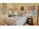 Sun-filled bedroom with a white bed, bamboo blinds, and tropical decor, creating a relaxing and stylish retreat at 701 Marbury Lane, Longboat Key, FL 34228