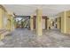Spacious carport featuring gray tile flooring, staircase, and a comfortable lounge area with rocking chairs at 701 Marbury Lane, Longboat Key, FL 34228