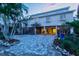 Charming two-story home with a landscaped yard, paved driveway, and well-lit carport area at 701 Marbury Lane, Longboat Key, FL 34228