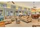 Open-concept living room featuring comfortable floral sofas, tile floor and seamless access to the adjacent dining area at 701 Marbury Lane, Longboat Key, FL 34228