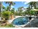 Relaxing backyard pool area surrounded by lush tropical plants, stone patio, and lounge chairs at 701 Marbury Lane, Longboat Key, FL 34228