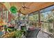 Outdoor porch with wood ceiling, ceiling fans, comfortable seating, and lush tropical plants at 701 Marbury Lane, Longboat Key, FL 34228