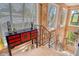 Upstairs landing with staircase, vintage cabinet, and bright light from shuttered windows at 701 Marbury Lane, Longboat Key, FL 34228