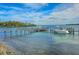 Scenic waterfront view featuring clear blue waters, a private dock, boats and lush green vegetation at 701 Marbury Lane, Longboat Key, FL 34228