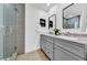 Contemporary bathroom with dual vanity, sleek gray cabinets, and a glass-enclosed shower at 8001 13Th S Ave, St Petersburg, FL 33707