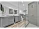 Modern bathroom with double vanity, gray cabinets, and glass-enclosed shower with gray tiling and brushed nickel fixtures at 8001 13Th S Ave, St Petersburg, FL 33707
