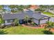 Charming single-story home with a well-manicured lawn, palm trees, and a brick walkway leading to the front door at 8001 13Th S Ave, St Petersburg, FL 33707