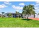 Well-maintained home with a spacious front yard, mature palm trees, and a blue front door at 8001 13Th S Ave, St Petersburg, FL 33707