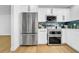 Modern kitchen boasts stainless steel appliances and white cabinets with blue tiled backsplash at 8001 13Th S Ave, St Petersburg, FL 33707