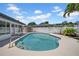Backyard pool view with steps into the pool and a white fence surrounding the pool area at 8001 13Th S Ave, St Petersburg, FL 33707