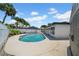 Private backyard pool surrounded by tropical landscaping and a white fence at 8001 13Th S Ave, St Petersburg, FL 33707
