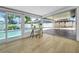Bright sunroom featuring an office desk, pool views, and access to an outdoor seating area at 8001 13Th S Ave, St Petersburg, FL 33707