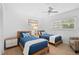 Bright bedroom with two twin beds, light colored walls, and a ceiling fan at 915 Beach Rd # 321, Sarasota, FL 34242