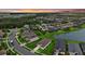An aerial view of a neighborhood showcasing luxurious homes, manicured lawns, and scenic water views at sunset at 9291 Starry Night Ave, Sarasota, FL 34241