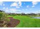 Picture of a well manicured backyard featuring a pond, tall green grass, and mulch ground cover at 9291 Starry Night Ave, Sarasota, FL 34241