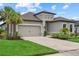 View of well maintained one-story home and 2 car garage with well manicured front lawn and landscaping at 9291 Starry Night Ave, Sarasota, FL 34241