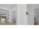 Hallway featuring light tile floors, bright lighting, and open doorways, creating an inviting atmosphere at 9291 Starry Night Ave, Sarasota, FL 34241