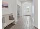 Hallway featuring light tile floors, a bench, and bright lighting, creating an inviting atmosphere at 9291 Starry Night Ave, Sarasota, FL 34241