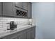 Kitchen countertop area with subway tile backsplash, gray cabinets, and wine rack at 9291 Starry Night Ave, Sarasota, FL 34241