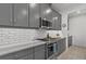 Modern kitchen featuring sleek countertops, stainless steel gas range, gray cabinets, and subway tile at 9291 Starry Night Ave, Sarasota, FL 34241