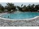 A large community pool featuring a splash pad, lounge chairs, and shady cabanas at 9291 Starry Night Ave, Sarasota, FL 34241