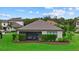 The rear exterior featuring a covered patio, enclosed backyard, and verdant landscaping in a serene setting at 9291 Starry Night Ave, Sarasota, FL 34241