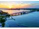 Scenic aerial view of the waterfront, a bridge, and a boat in the water at sunset at 1000 Longboat Club Road # 1105, Longboat Key, FL 34228