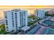 Beautiful aerial view of beachfront condos, a community pool, and tennis courts at sunset at 1000 Longboat Club Road # 1105, Longboat Key, FL 34228