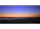 Serene sunset beach view with orange sky reflecting on calm waters and tranquil shoreline at 1000 Longboat Club Road # 1105, Longboat Key, FL 34228